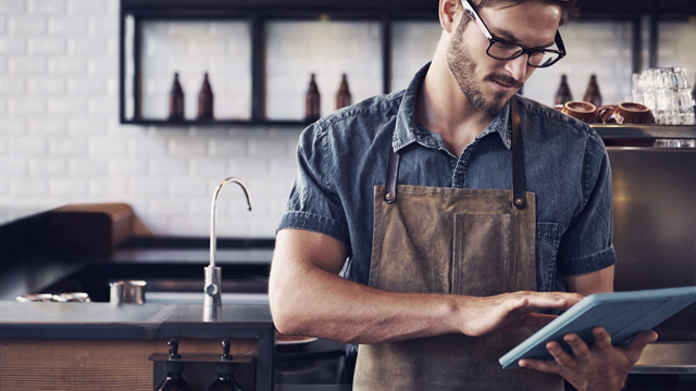 Waiter man in a cafe looking at his tablet 