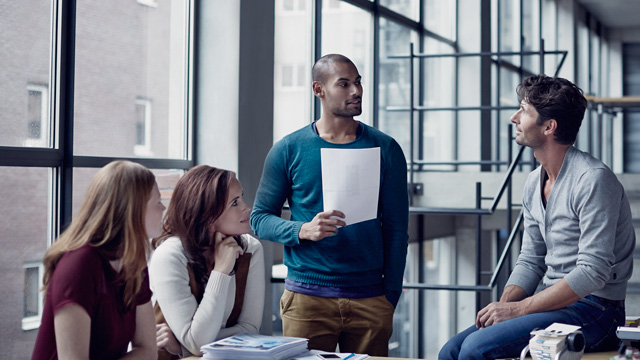 Informal business meeting with four people talking in an office