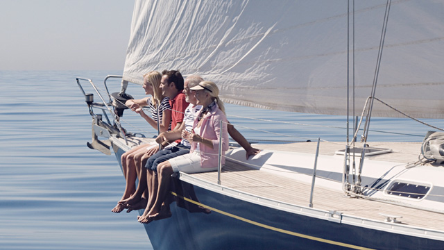 People sitting on the rails on a sailing boat
