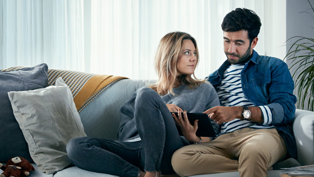 Couple at home looking at a pad together.