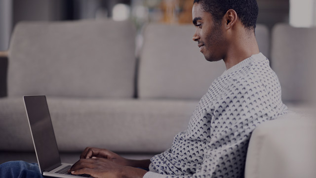 Man in sofa with laptop.