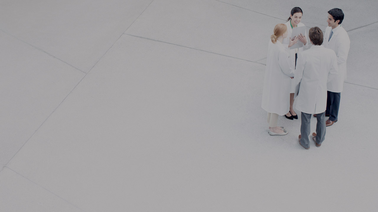 People in white coats having a standing meeting large