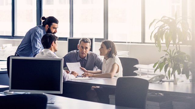 Office with four people talking 