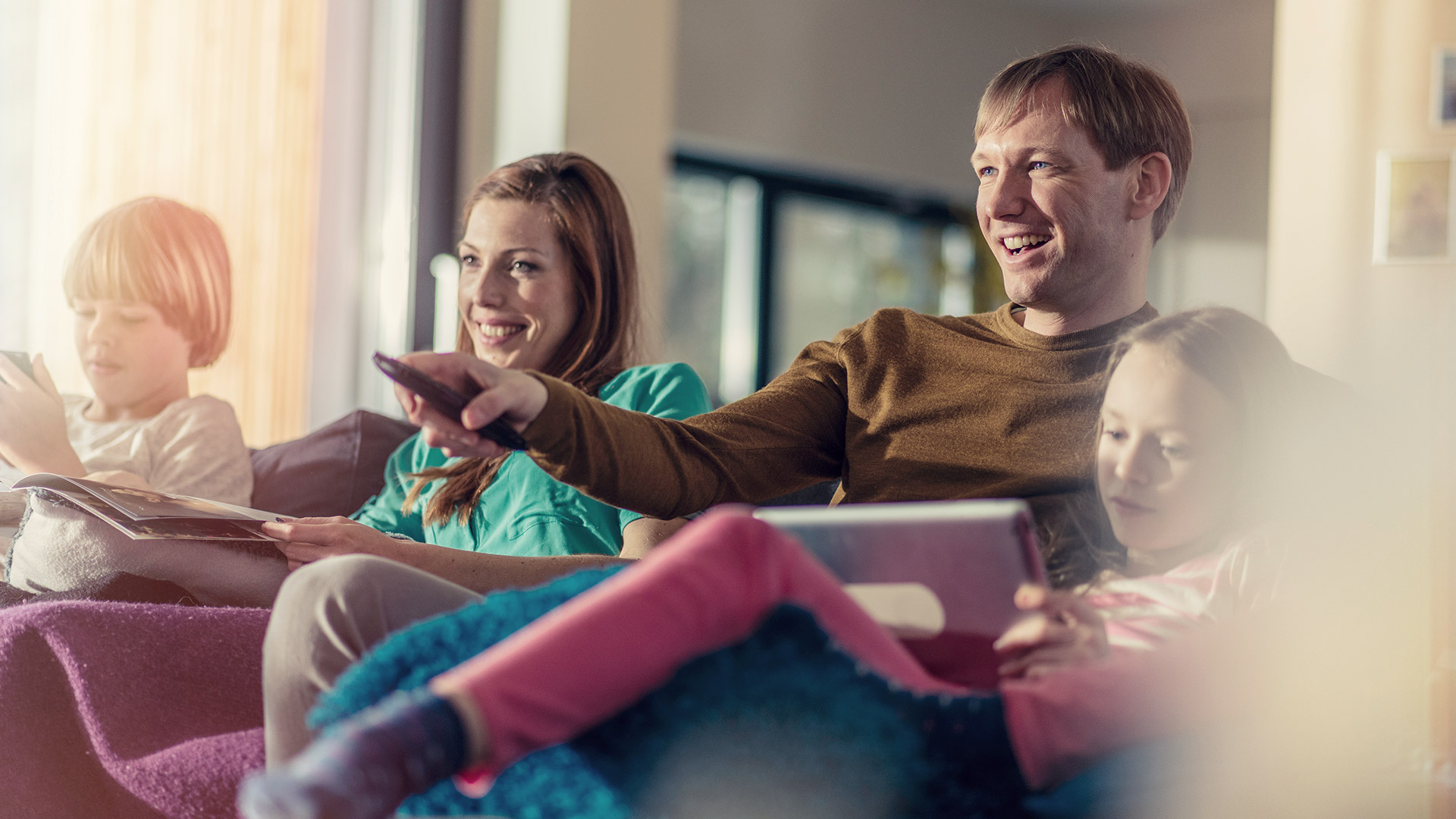 family with remote control in sofa