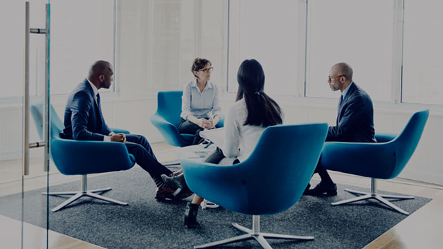 mature businesswoman leading meeting in office small overlay