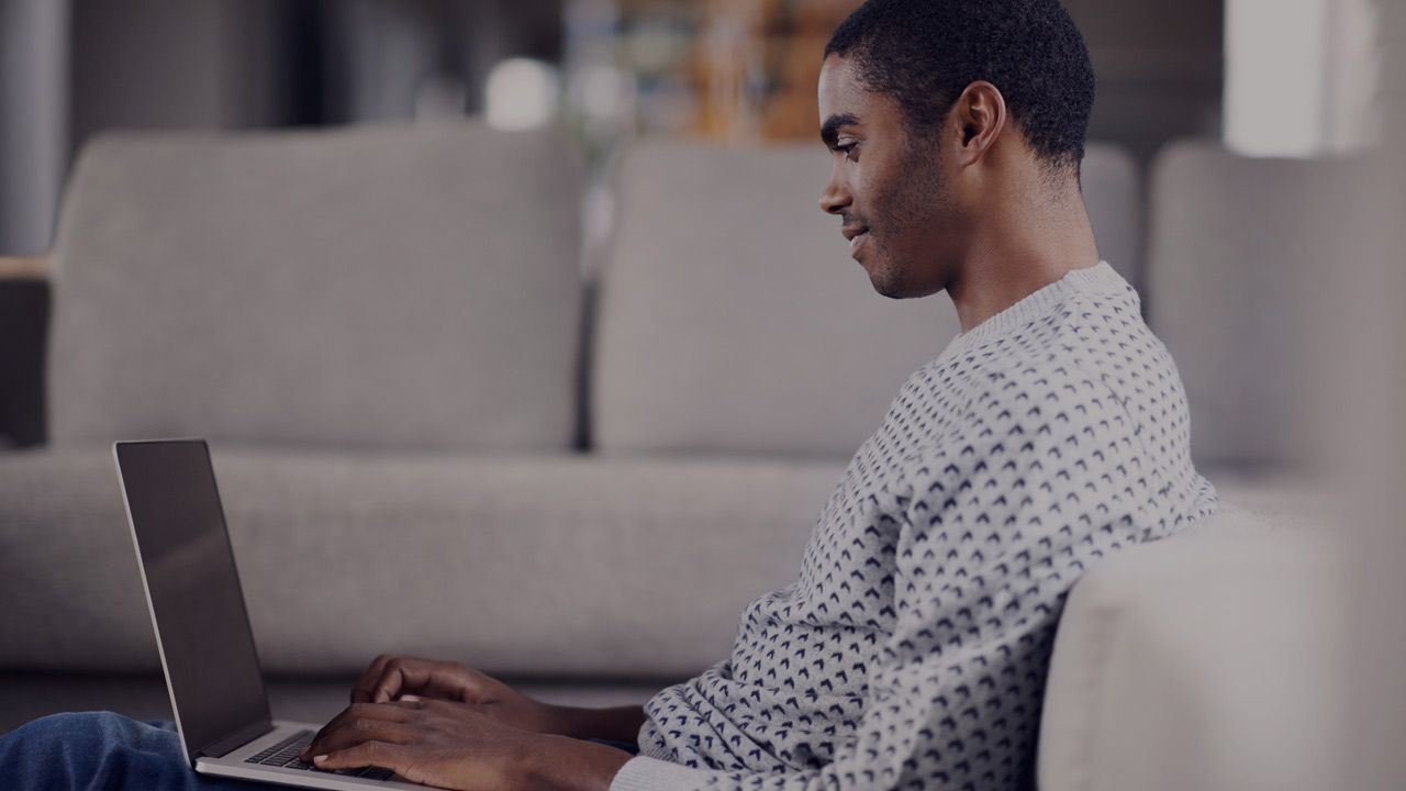 Man in sofa with laptop.