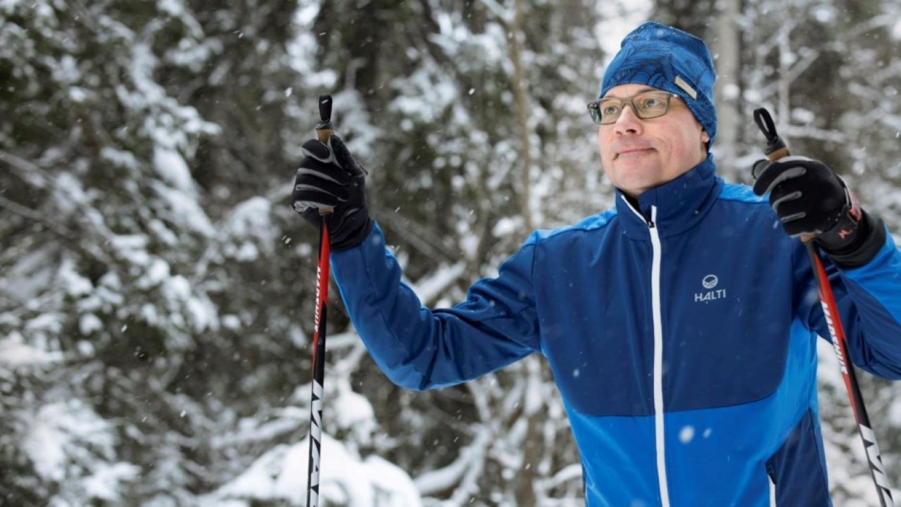 Mies hiihtää talvisessa luonnossa.
