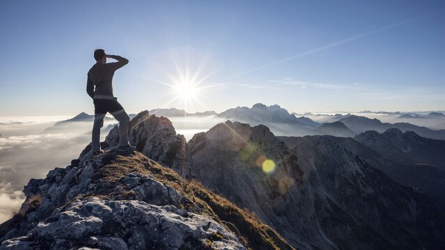Climber standing on a mountain peak SMALL