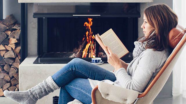 Woman in designer chair in front of fire place