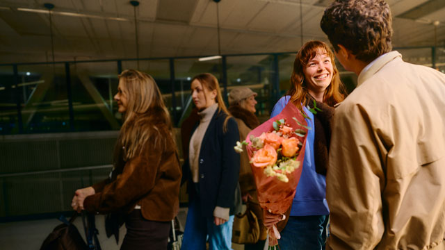Young adult woman greeted with flowers Small
